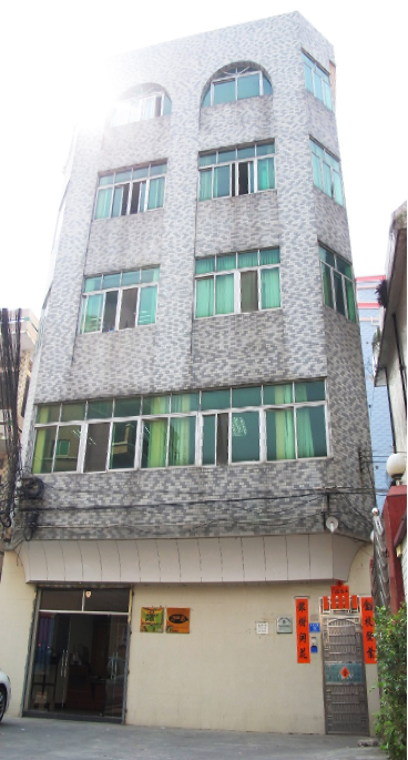 一棟大樓，前面停著一輛汽車。