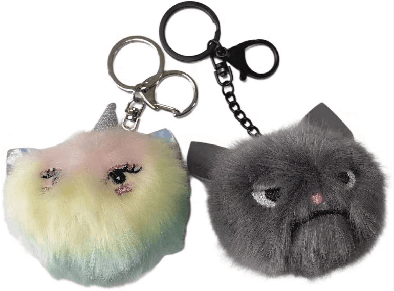 在白色背景上的兩個毛茸茸的貓鑰匙圈。