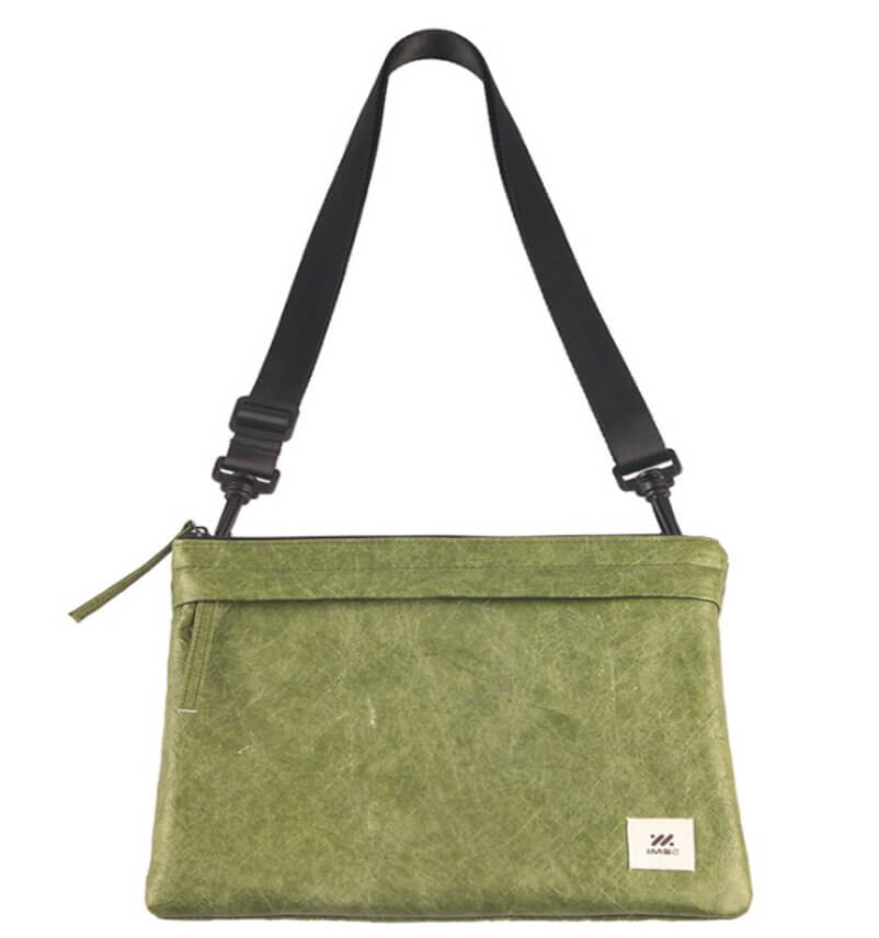 綠色斜背包,搭配黑色肩帶。