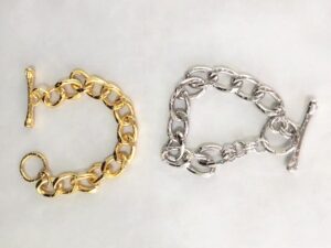 白色表面上有兩個金銀鍊手鐲。