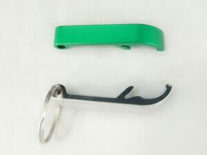 白色表面上的綠色開瓶器和鑰匙圈。